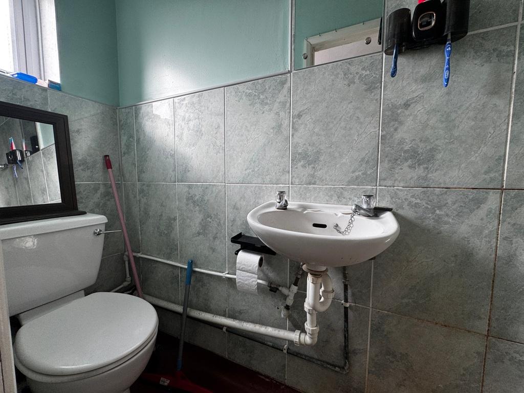 Compact tiled bathroom with a toilet and wall-m...