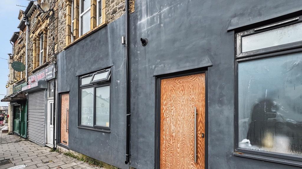 Street-level shopfront with a fresh dark grey f...
