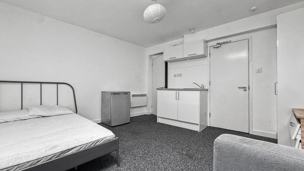 Well-kept single bedroom with a simple metal do...