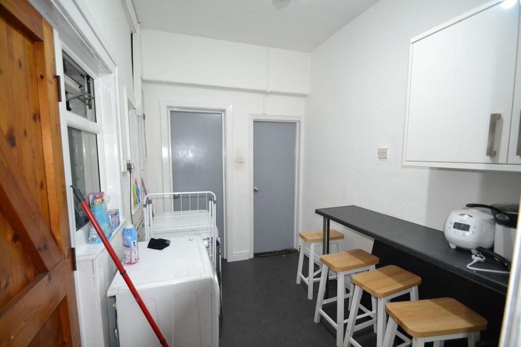 Long narrow kitchen/utility area with a breakfa...