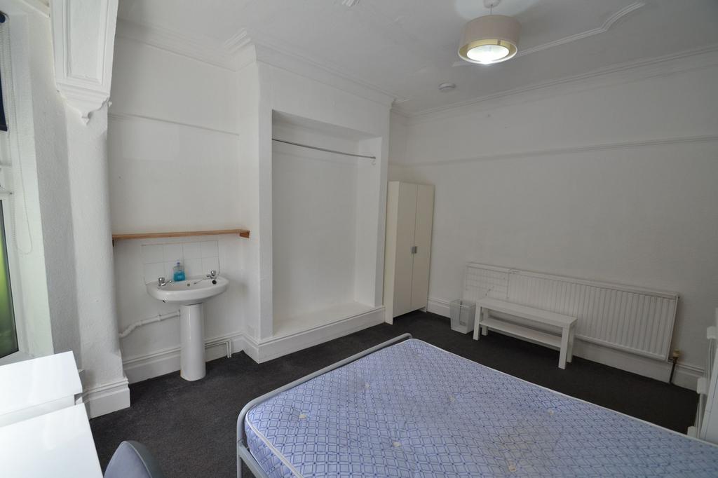 Bright, neutral bedroom with a double bed frame...