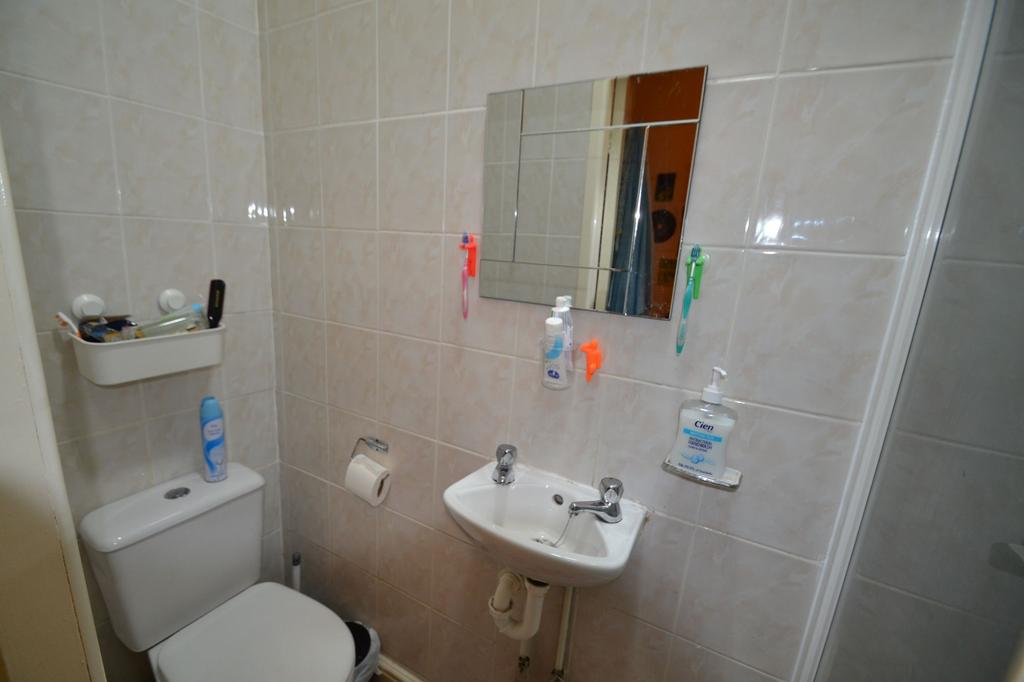 A clean and functional bathroom with tiled wall...