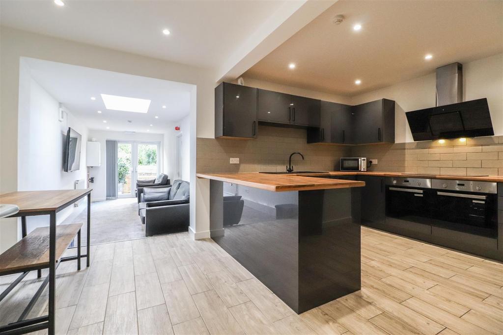 Modern open-plan kitchen with seating and islan...