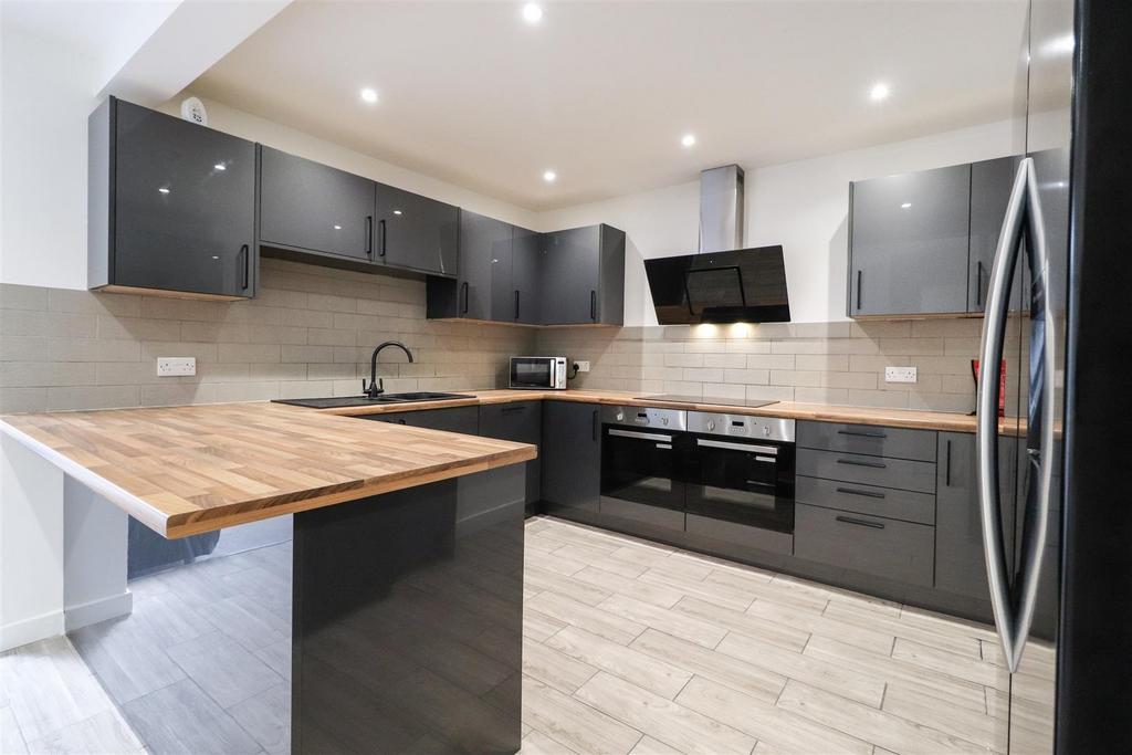 Modern fitted kitchen with wood counters...
