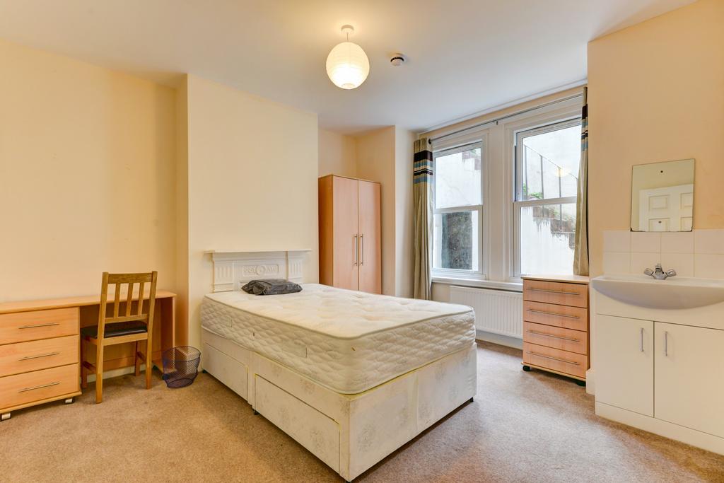 A well-lit bedroom featuring a comfortable doub...