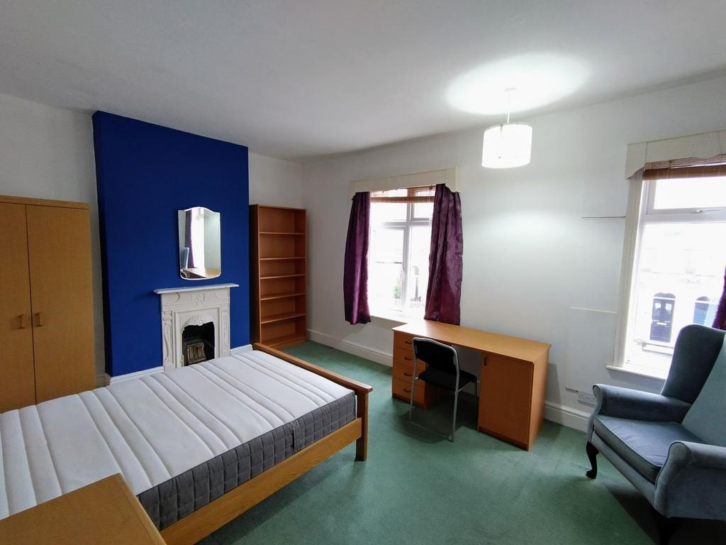 Bright double bedroom with desk and fireplace...