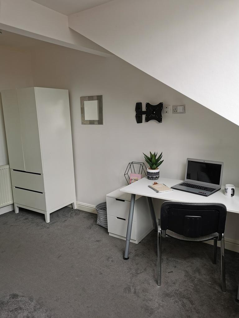 Bright, neatly presented bedroom corner with a ...