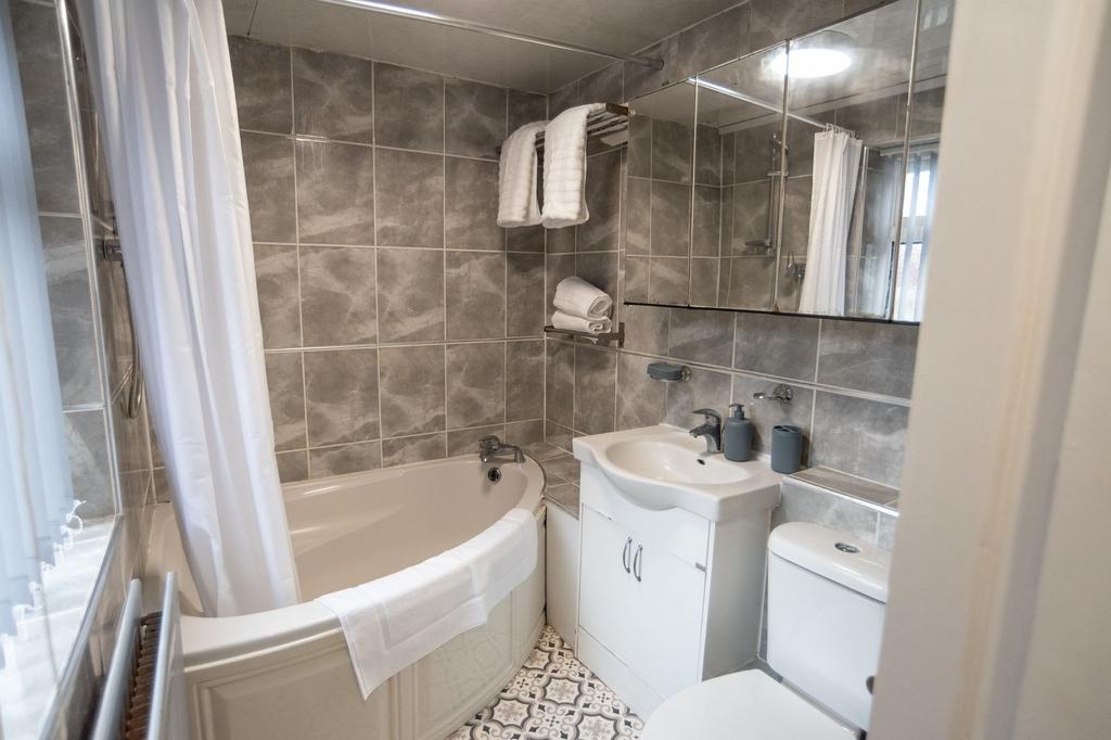 Bright, well-maintained bathroom with a corner ...