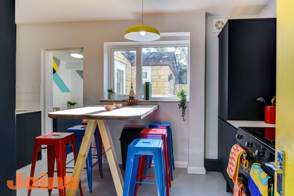 Bright, modern kitchen featuring a wooden high ...