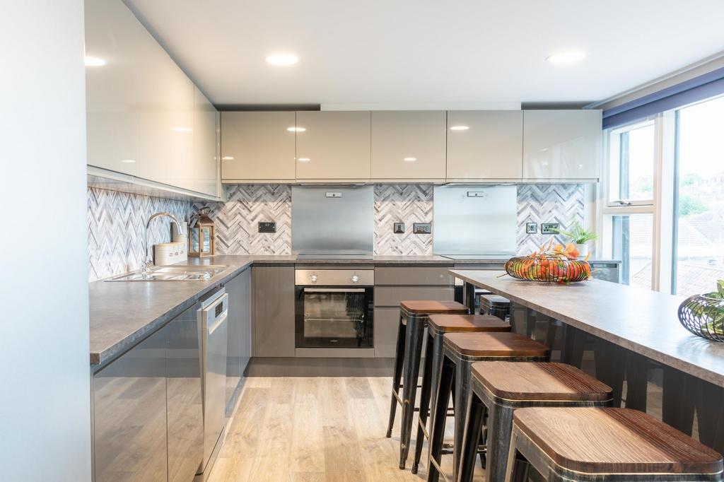 Modern fully fitted kitchen with sleek grey cab...
