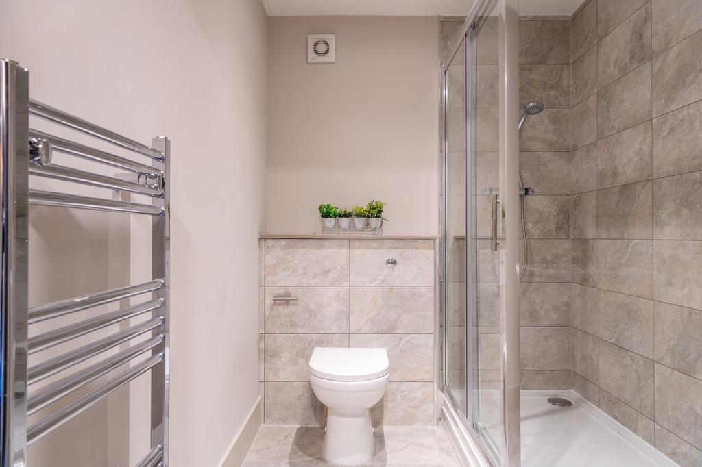 Modern tiled bathroom with a walk-in shower, wa...