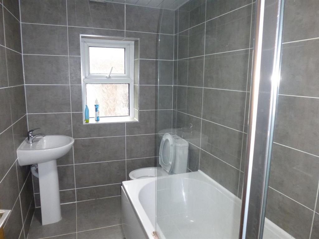 Modern tiled bathroom with a bath, shower enclo...
