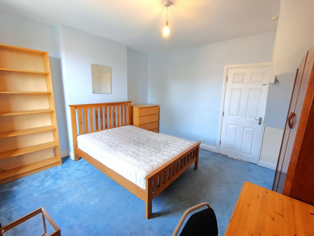 Bright, well-presented bedroom with a wooden do...