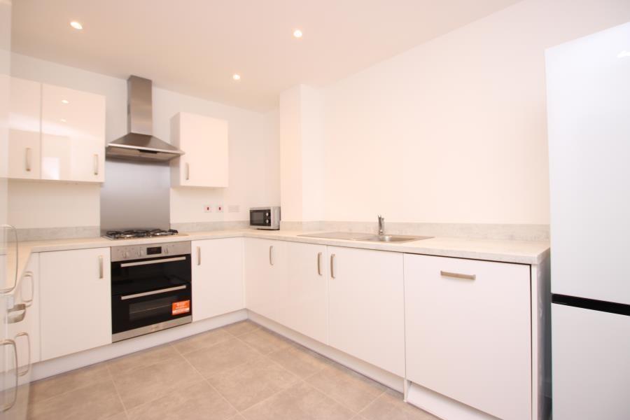 Bright modern kitchen with white cabinetry, int...