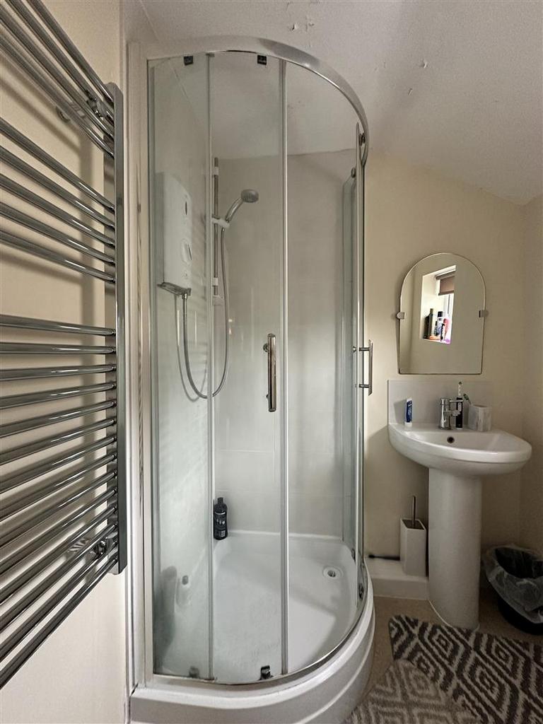 Bright modern bathroom with curved glass shower...