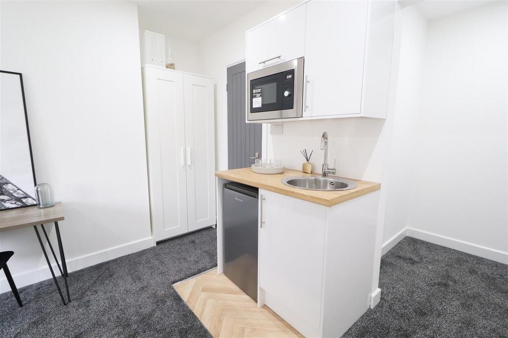 Compact kitchenette with integrated appliances...