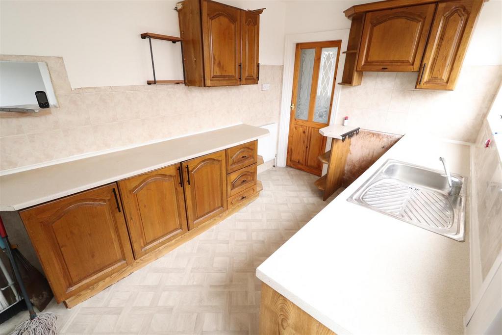 Bright kitchen with wooden cabinetry and sink...