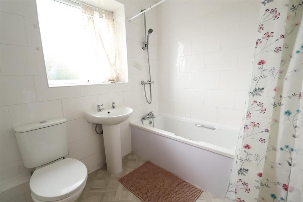 Clean, bright bathroom with bath and shower...