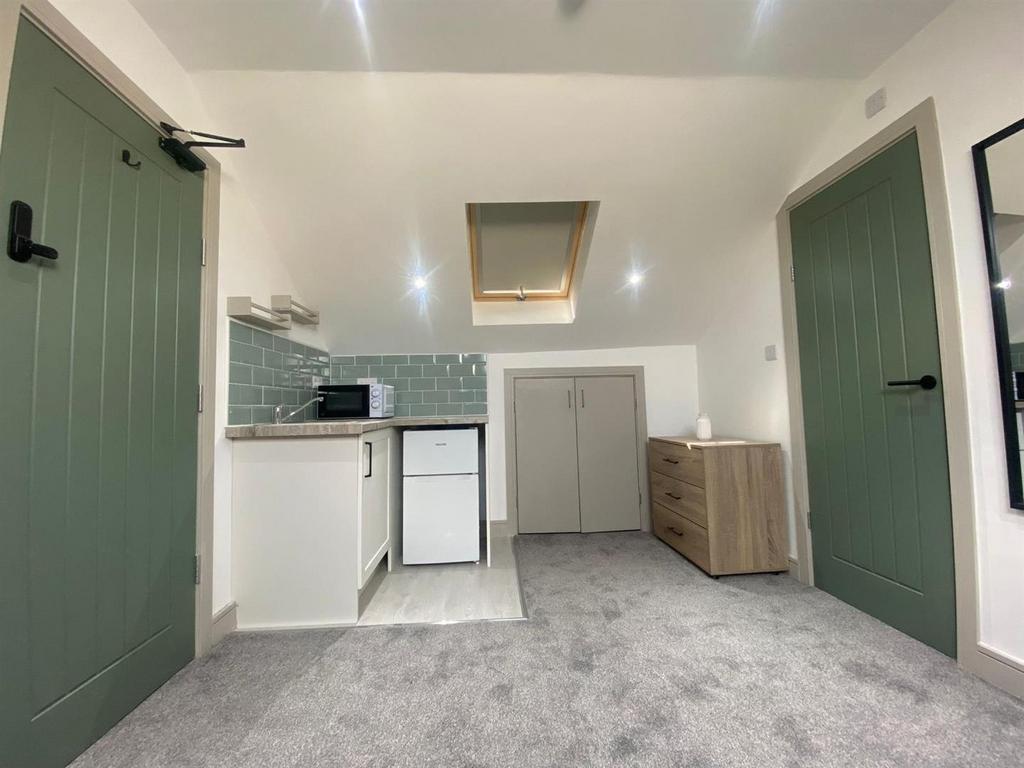 Bright, freshly carpeted studio space with a co...