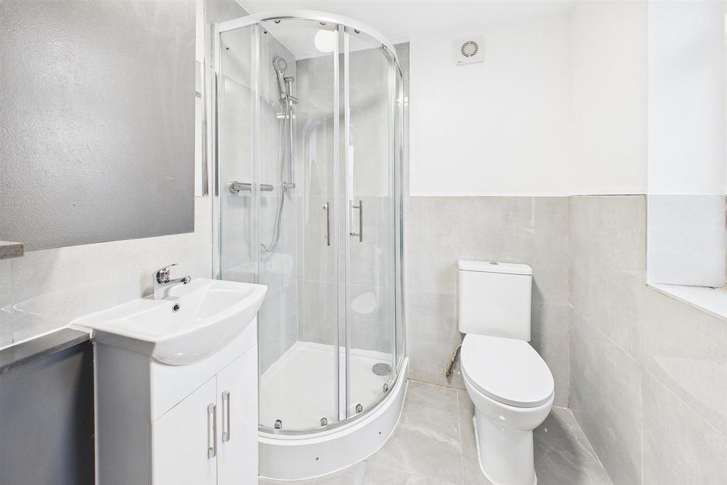 Bright, modern bathroom with a curved glass sho...