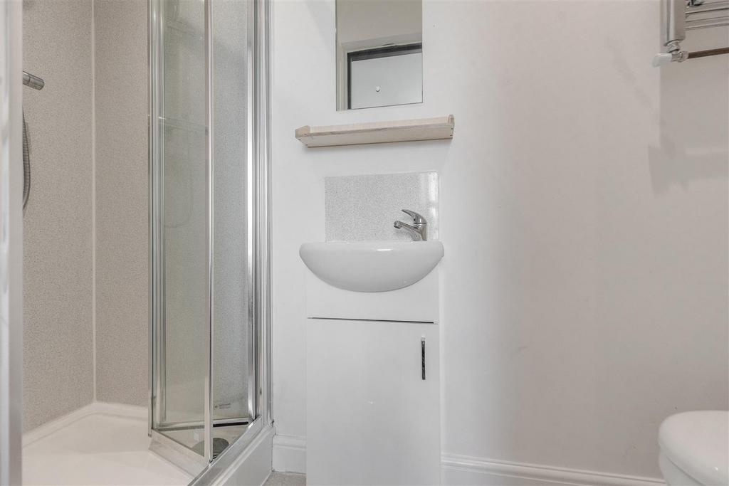 Bright, modern bathroom with a corner glass sho...