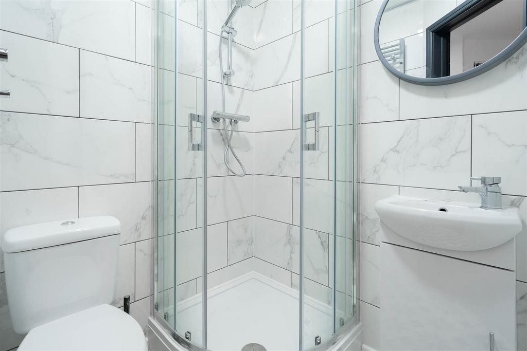 Bright, modern bathroom with a corner glass sho...