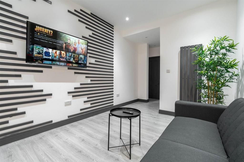 Contemporary living room with a wall-mounted TV...