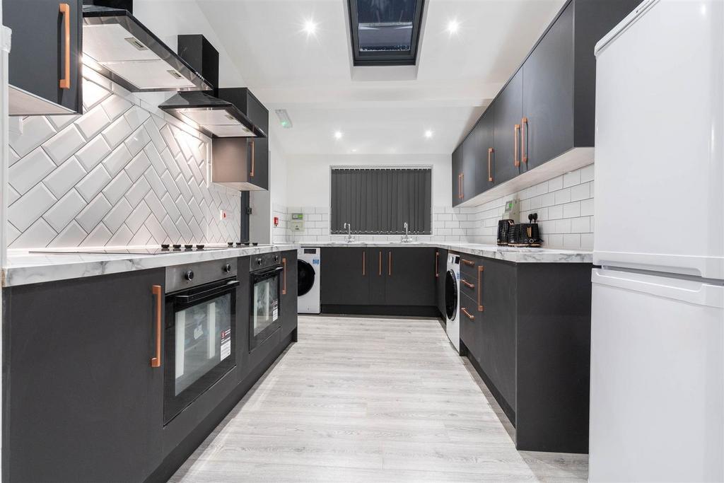 Modern galley kitchen with sleek dark cabinetry...