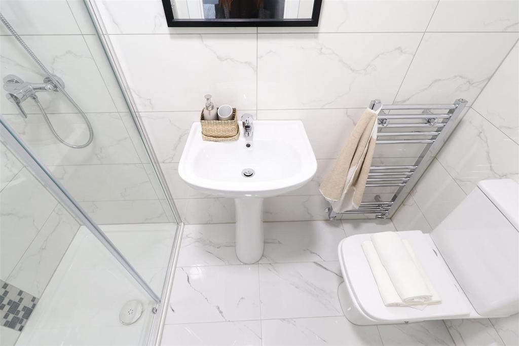Bright modern bathroom with shower and clean ti...