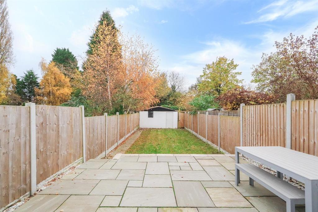 Well-maintained rear garden with a paved patio,...