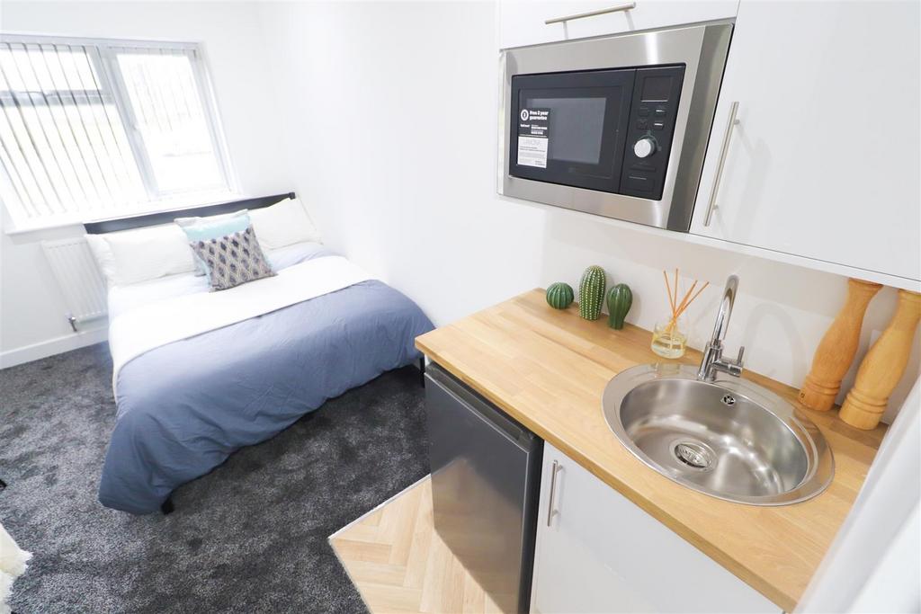Bright, modern bedroom with kitchenette and nea...