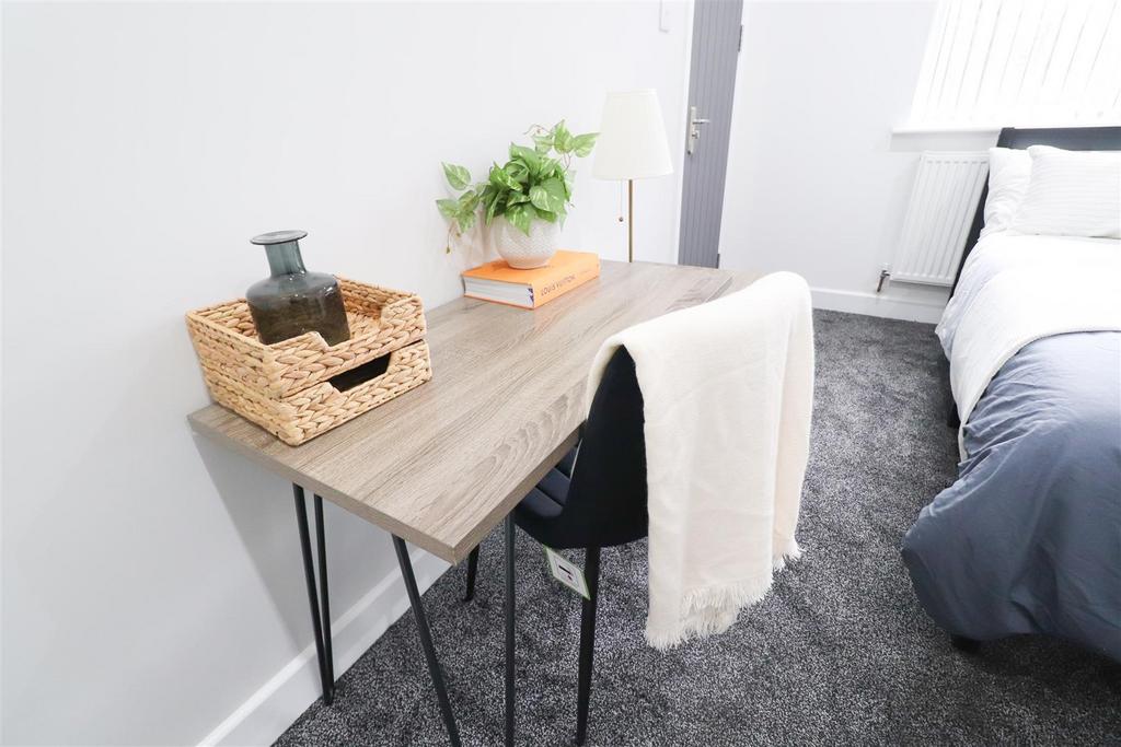Bright bedroom with neat desk and comfy bed...