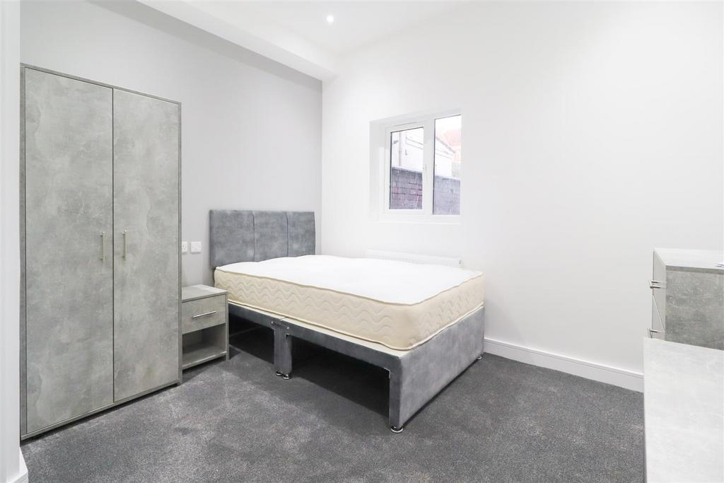 Bright, simply furnished bedroom with a double ...