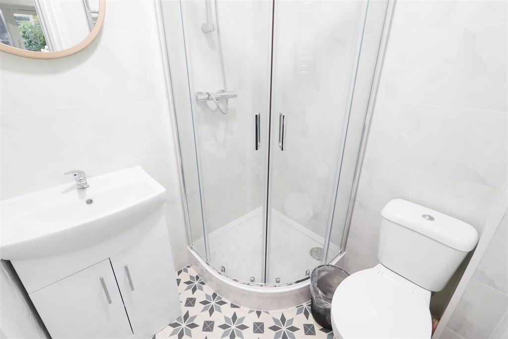 Bright, modern bathroom with a curved glass sho...