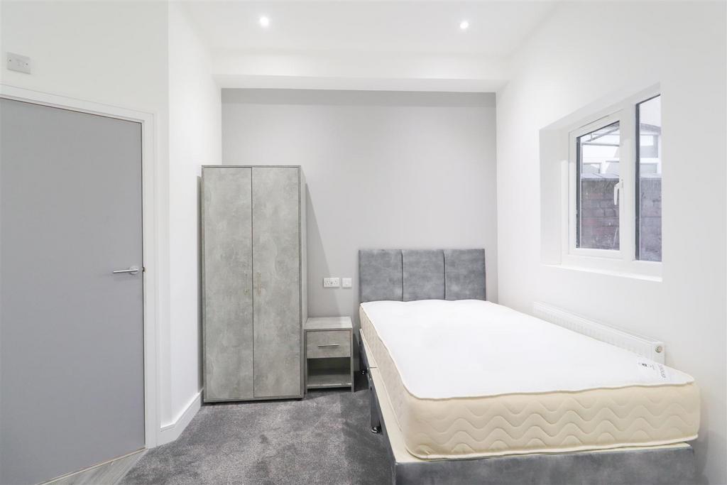 Bright, simply furnished bedroom with neutral d...