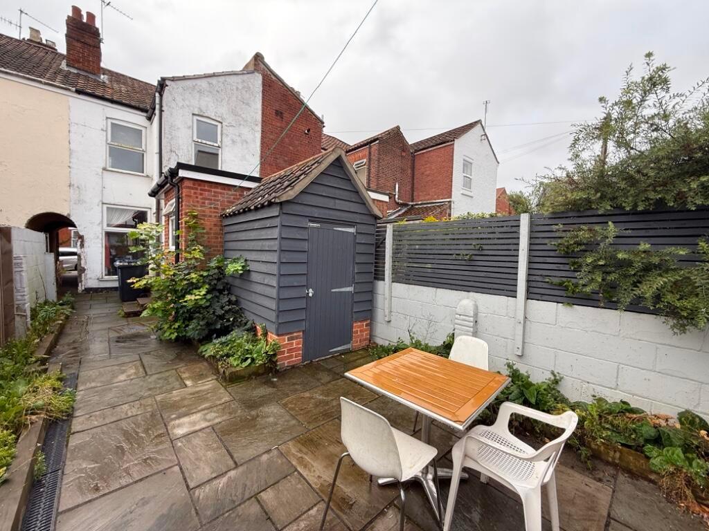 Private paved rear courtyard with a timber stor...