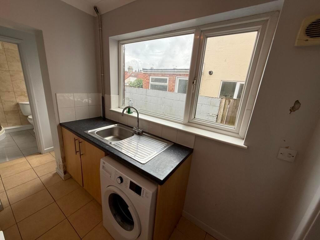 Compact galley-style kitchen with a large windo...