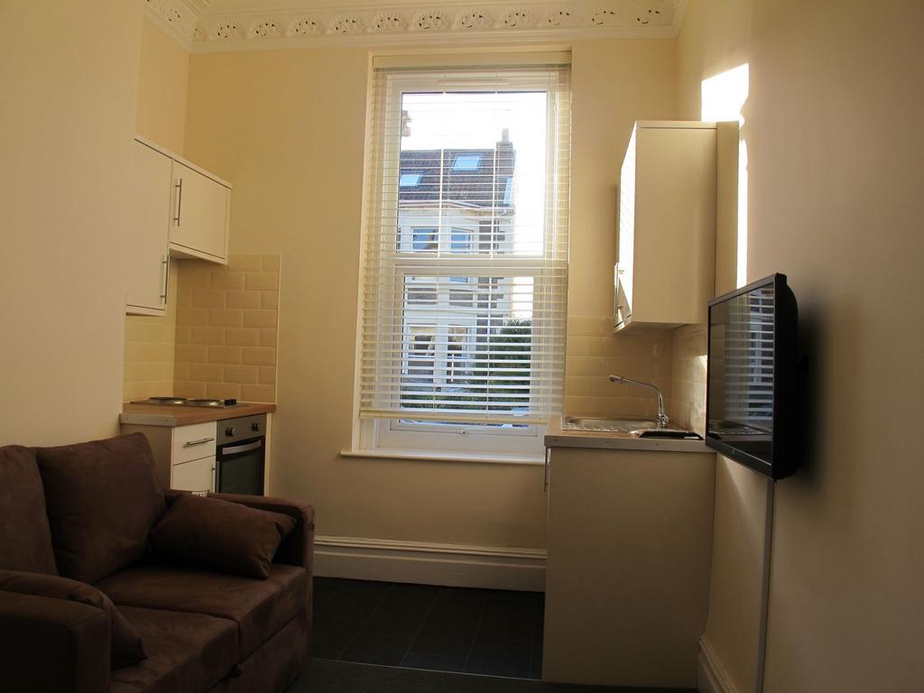 Compact studio living area with kitchen and win...