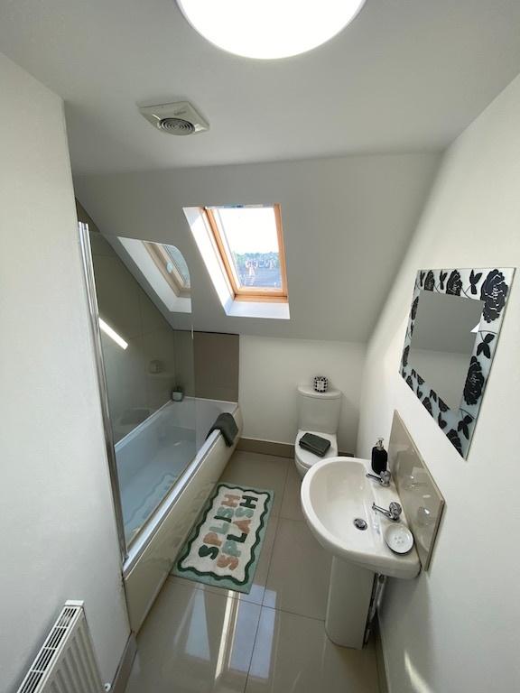 Bright, modern upstairs bathroom with a skyligh...
