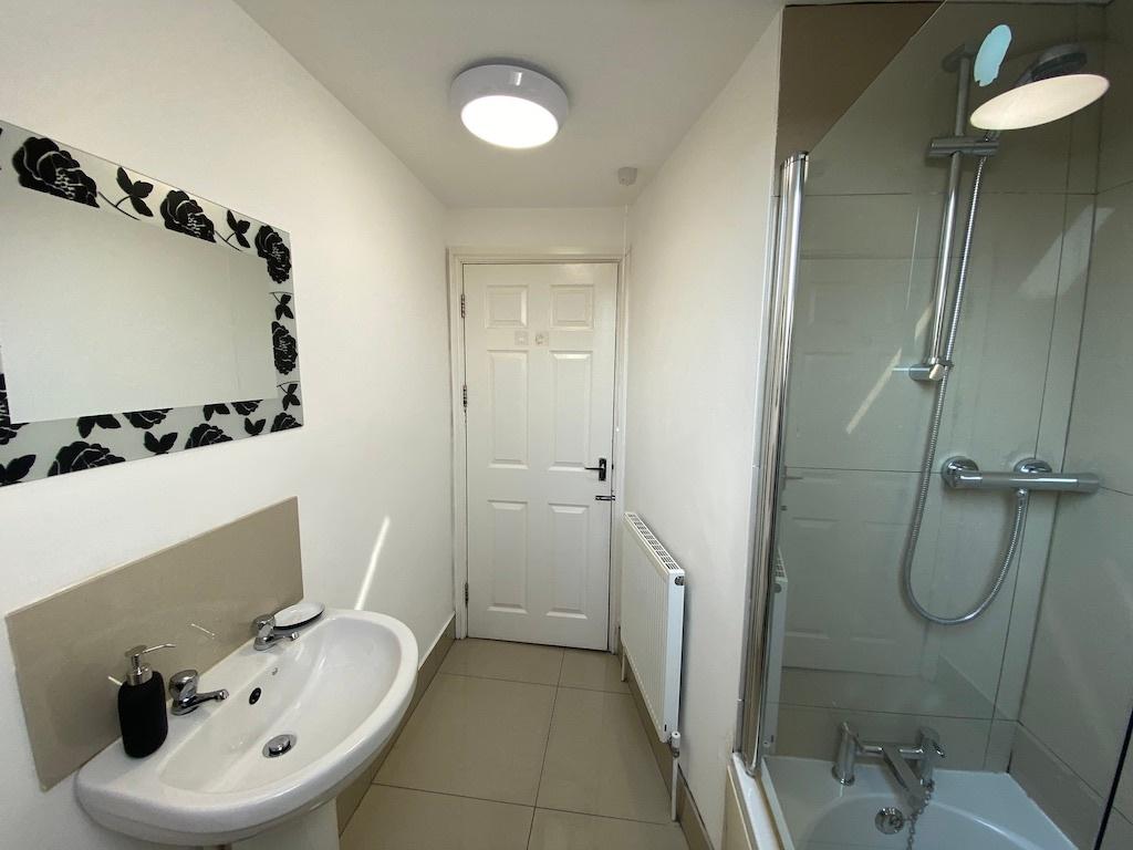 Bright, modern bathroom with a glass-enclosed s...