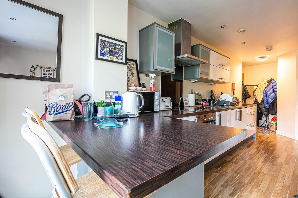Modern open-plan kitchen with a long dark wood ...