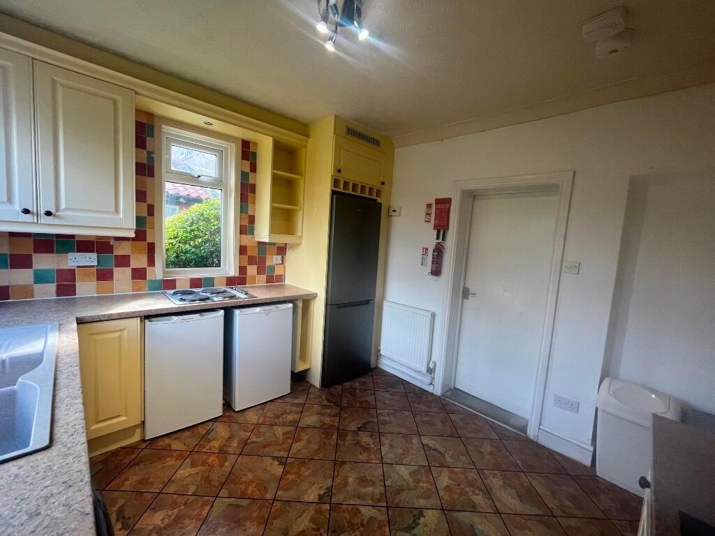 Bright, well-equipped kitchen with patterned ti...