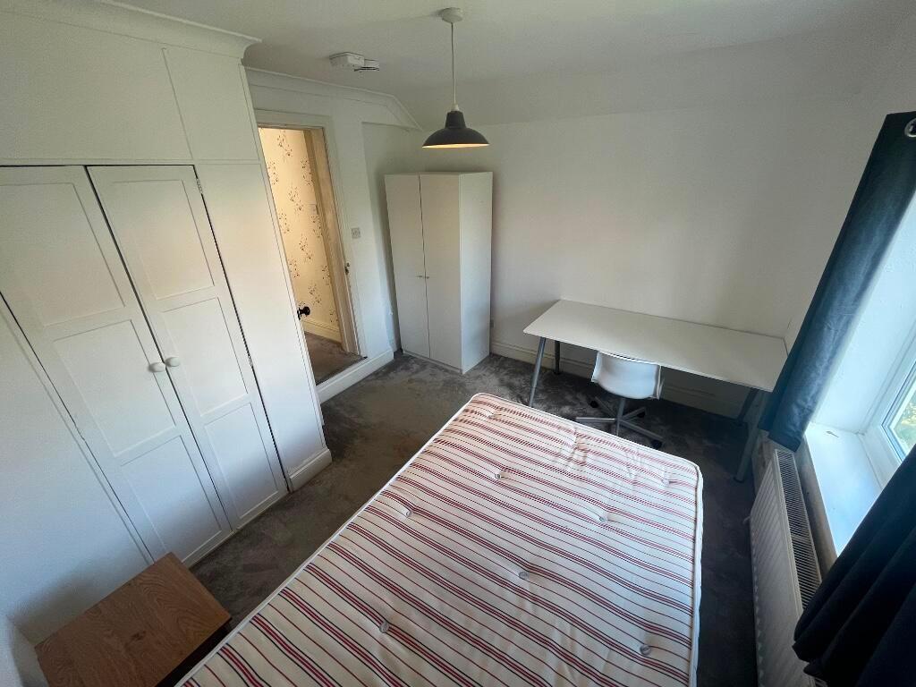 Bright, neutrally decorated double bedroom with...