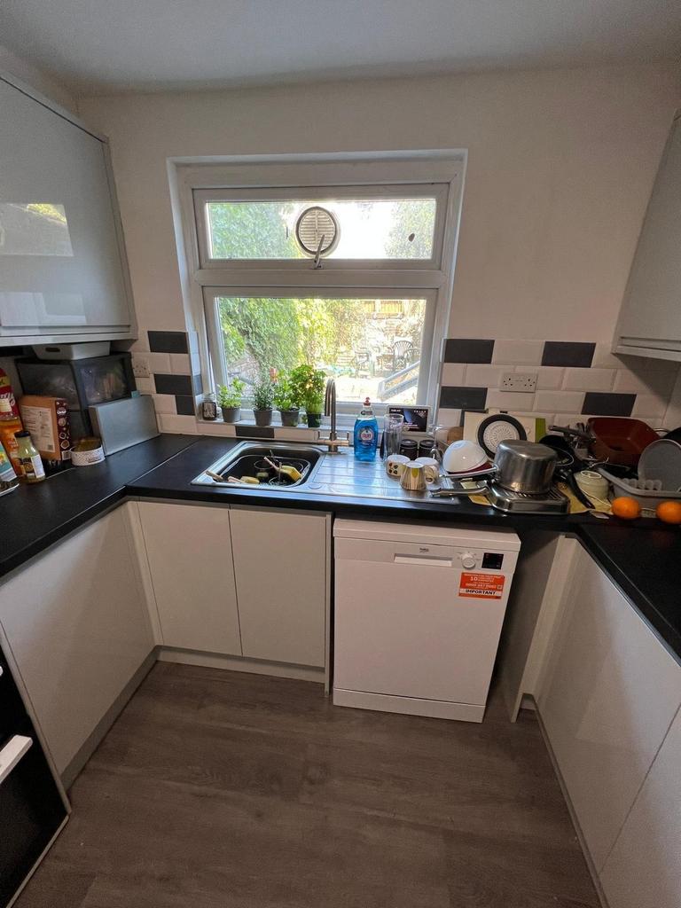 Modern galley-style kitchen with white cabinets...