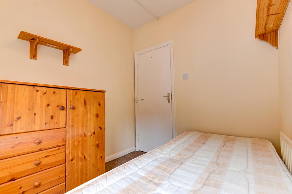 A cozy bedroom featuring a neatly made bed with...