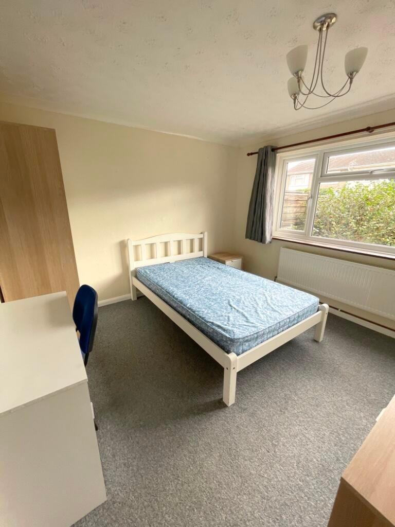 Bright, simply furnished bedroom with a single ...
