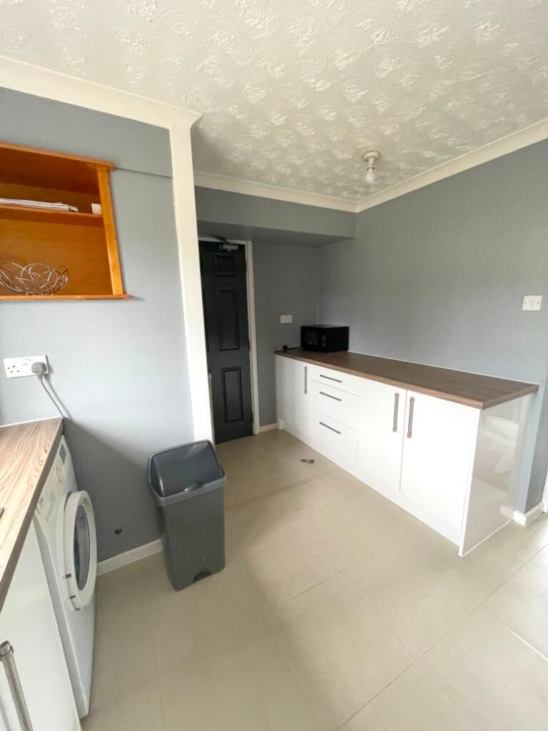 Clean, modern kitchen-style utility room with l...