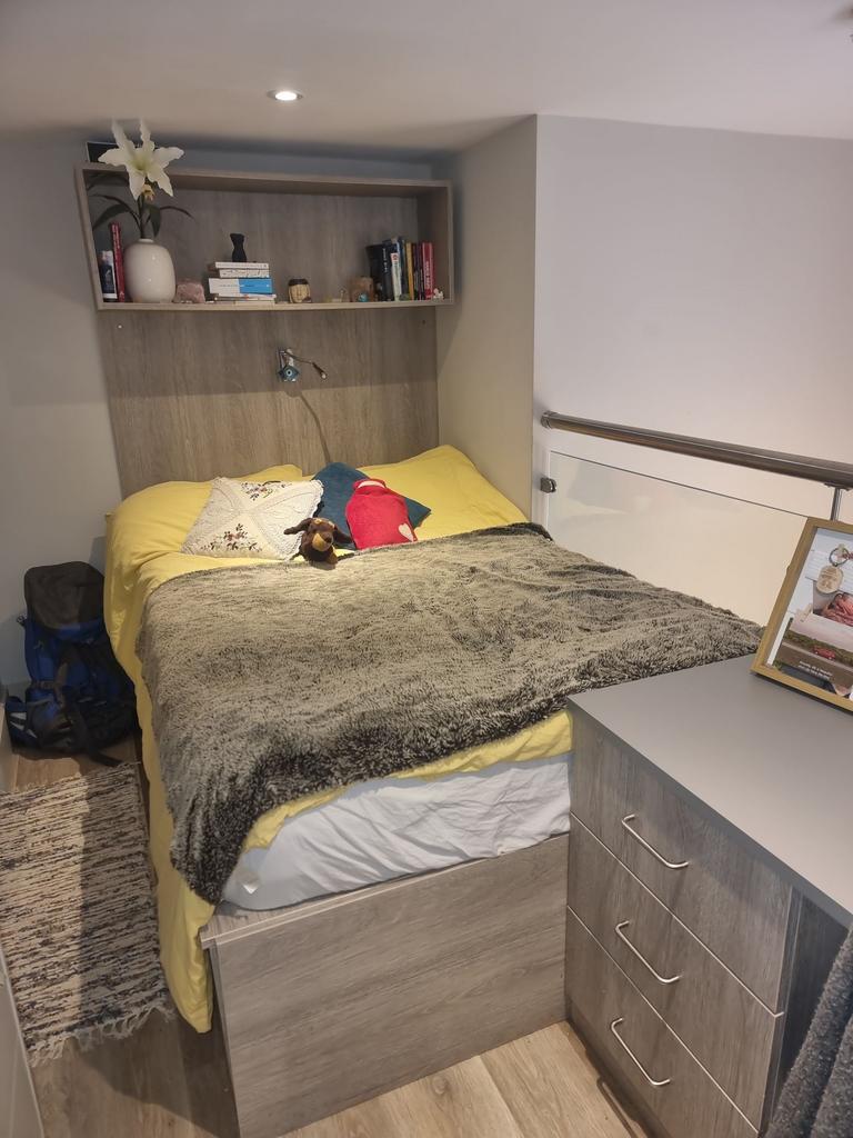 Cozy, well-presented bedroom with built-in shel...