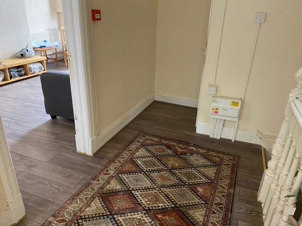A tidy hallway with wooden flooring and a decor...