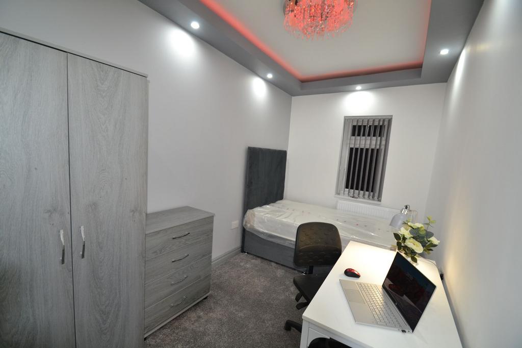 A cozy single bedroom featuring a single bed, a...